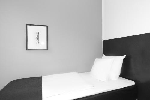a bedroom with a bed with a picture on the wall at Hotel Svendborg in Svendborg