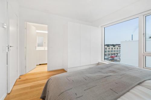 a bedroom with white walls and a large window at STAY Bryggen in Copenhagen