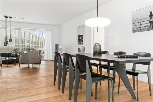 a dining room with a black table and chairs at STAY Bryggen in Copenhagen