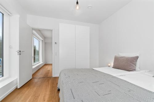 a white bedroom with a bed and a window at STAY Bryggen in Copenhagen