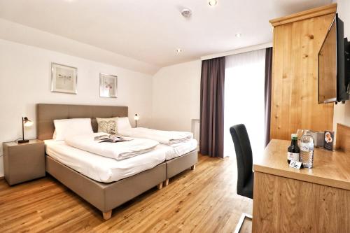 1 dormitorio con 1 cama y escritorio en una habitación en Seelos - Alpine Easy Stay - Bed & Breakfast, en Mieming
