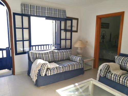a living room with two couches and a glass table at Apartamento La Caleta in Famara