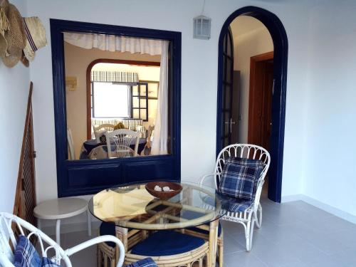a dining room with a glass table and chairs at Apartamento La Caleta in Famara