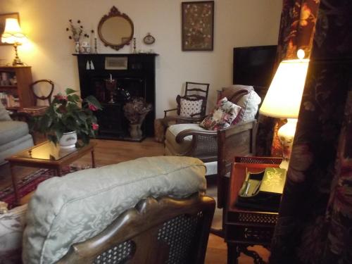 a living room filled with furniture and a lamp at The Apartment of Antiquity in Kirkby Stephen