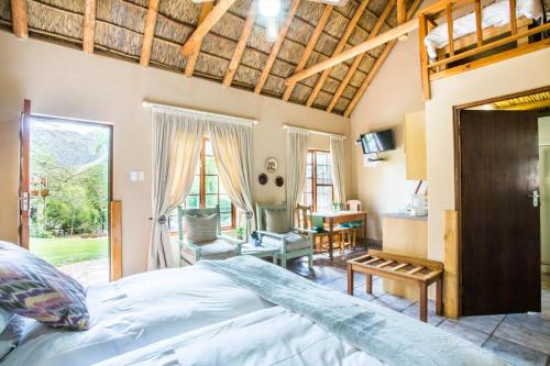 a bedroom with a bed and a living room at De Poort Country Lodge in Oudtshoorn