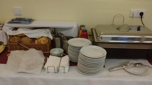 a table with a pile of plates and a sink at Penzion U sv. Kryštofa in Prague