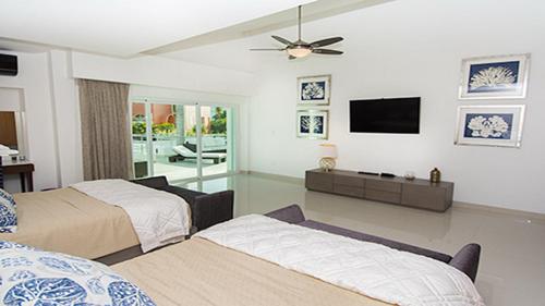 1 dormitorio con 2 camas y TV de pantalla plana en CortesStars, en Cancún