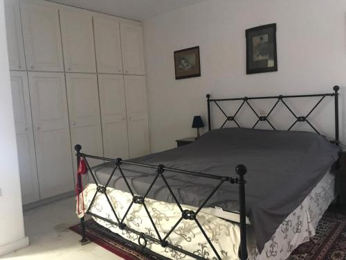 a bedroom with a bed with a wrought iron frame at Mykonos Beachfront House with Sunset & Delos View in Agios Stefanos