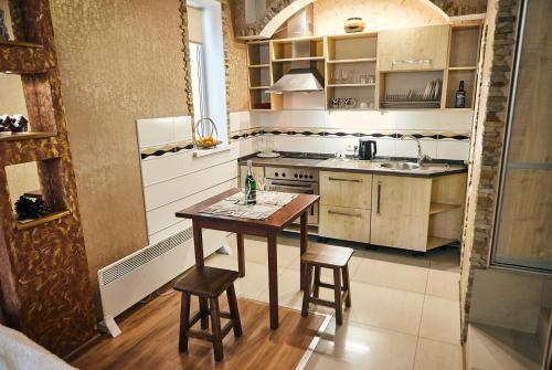 a kitchen with a table and two stools in it at Center Сozy in Vinnytsya