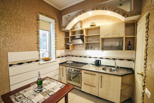 a kitchen with a sink and a stove and a table at Center Сozy in Vinnytsya
