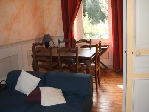 sala de estar con sofá azul y mesa en Maison de charme en Binic