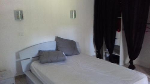 1 dormitorio con 1 cama blanca y 2 almohadas en palayson two, en Le Muy