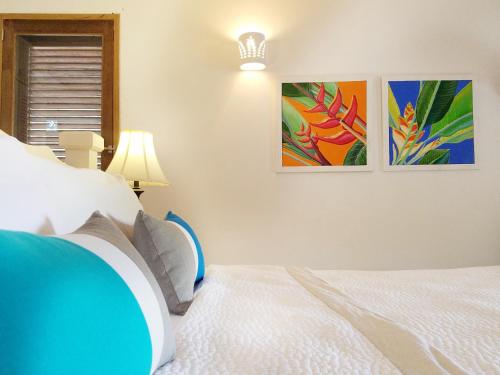 a bedroom with a bed and two pictures on the wall at Gingerbread Suites in Port Elizabeth