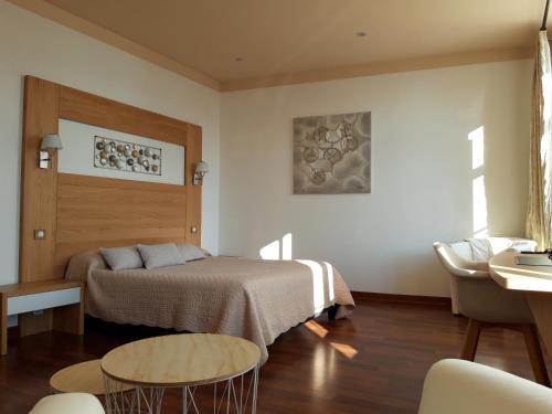 sypialnia z łóżkiem, stołem i krzesłami w obiekcie Hôtel la Guimbarde w mieście Morteau