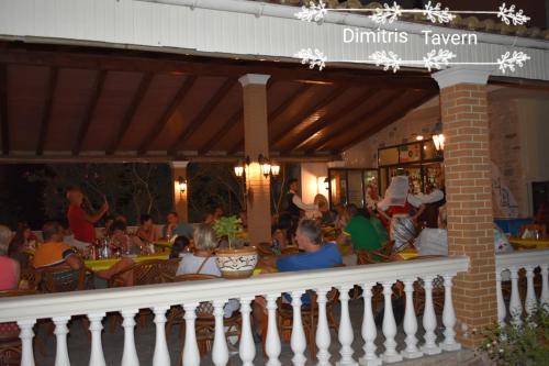 a group of people sitting at an outdoor restaurant at Anna Studios in Marathias