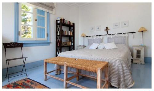 a bedroom with a bed and a table and a window at Villa Pitiousa in Spetses