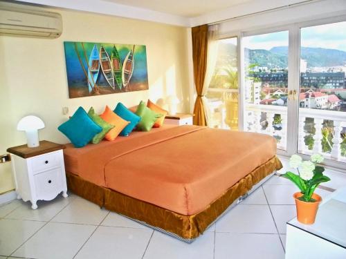 パトンビーチにあるVilla Versace Residenceの大きなベッドと大きな窓のある寝室
