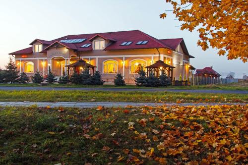 una casa grande con luces encendidas en un patio en Dworek Różany Hotel & Restauracja en Namysłów