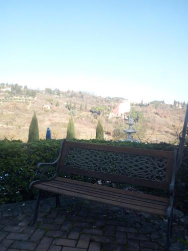 a wooden bench sitting on a brick walk way at Rocca Palazzaccio in Impruneta