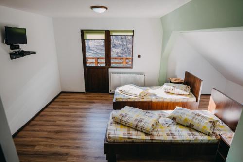 Cette chambre comprend 2 lits et une télévision. dans l'établissement Paradisul Verde, à Bretea