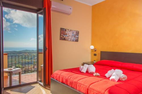 a bedroom with a red bed and a balcony at B&B Montemare in Agrigento