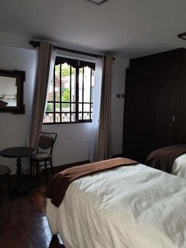 a bedroom with a bed and a window at El Jardin De Su Merced B&B in Sucre