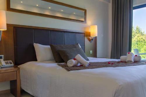 a bedroom with a bed with two stuffed animals on it at Rodon Hotel and Resort in Agros