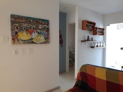 a living room with a painting on the wall at Residencial Praia dos Corais in Coroa Vermelha
