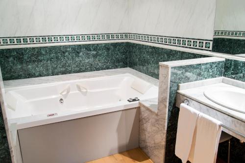 a bathroom with a sink, toilet and bathtub at Hotel Zentral Gijón Rey Pelayo in Gijón