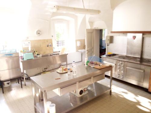 a kitchen with a table in the middle of it at Maison familiale des Gueyniers in Jausiers
