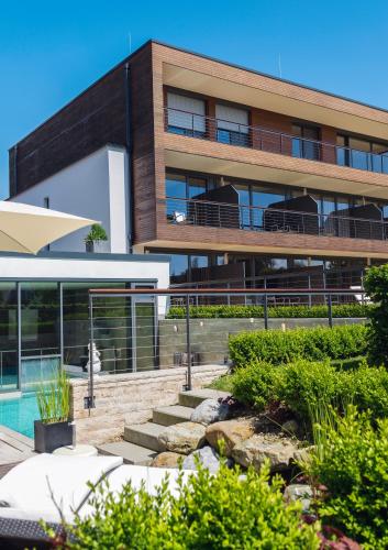 a building with a swimming pool in front of it at Hotel Restaurant Spa Torkel in Nonnenhorn