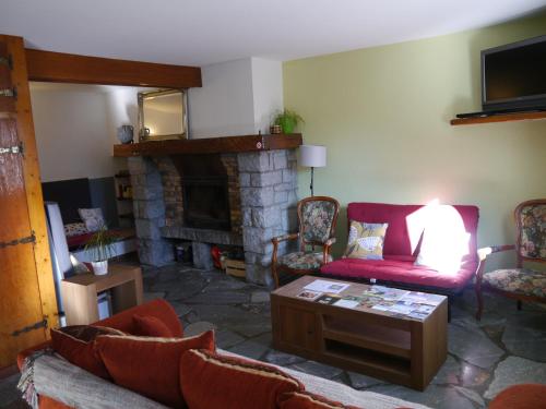 a living room with a red couch and a fireplace at Le Hameau de Campan in Sainte-Marie-de-Campan