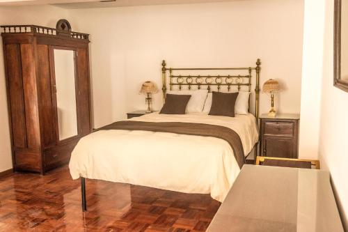 a bedroom with a large bed and a table at El Jardin De Su Merced B&B in Sucre