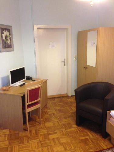 a room with a desk with a laptop and a chair at Hotel Deutsches Haus in Kurort Gohrisch