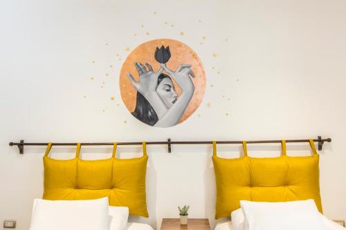 a bedroom with yellow pillows and a painting on the wall at X.O Art House in Cusco