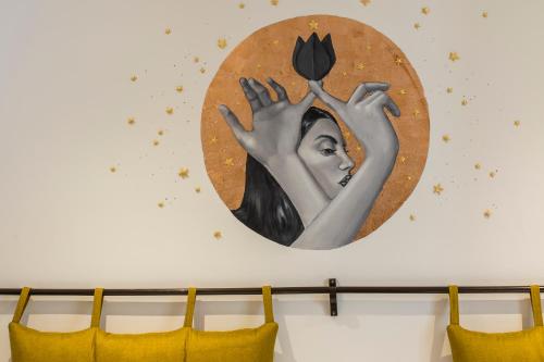 a painting of a woman holding a flower on a wall at X.O Art House in Cusco