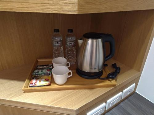 a cupboard with a coffee maker and two water bottles at Lantan Fanyue Inn in Chiayi City