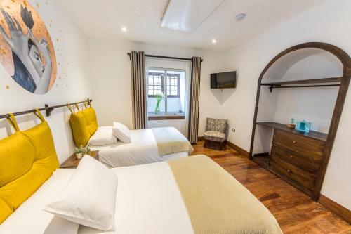 a hotel room with two beds and a mirror at X.O Art House in Cusco