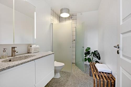 a white bathroom with a toilet and a shower at Årslev B&B in Randers