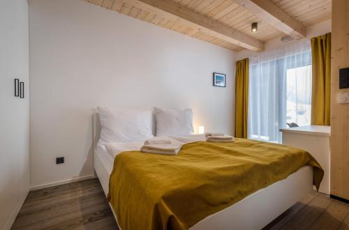 a bedroom with a bed with a yellow blanket on it at Demänová Rezort in Liptovský Mikuláš