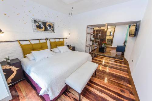 a bedroom with a large white bed and wooden floors at X.O Art House in Cusco