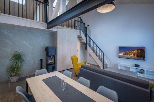 a dining room with a table and a yellow chair at Demänová Rezort in Liptovský Mikuláš