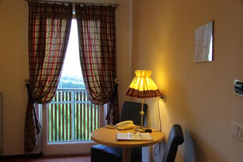 a room with a table and a lamp and a window at Hotel Hanny in Bolzano