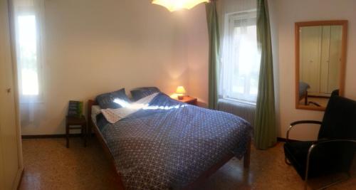 sypialnia z łóżkiem z niebieską kołdrą w obiekcie Gîte du Mas Arnaud w mieście Thuir