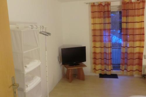 een kamer met een televisie op een tafel en een raam bij Casa Papa in Friedberg