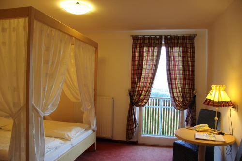 a bedroom with a bed and a window with a balcony at Hotel Hanny in Bolzano
