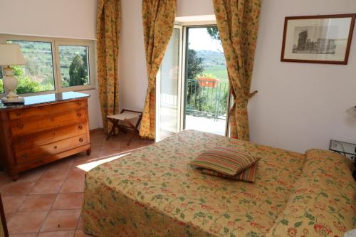 a bedroom with a bed and a dresser and a window at Tenuta Di Pietra Porzia in Frascati