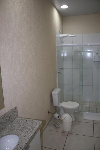 a bathroom with a toilet and a shower and a sink at Blu Apart Hotel in Mogi-Guaçu