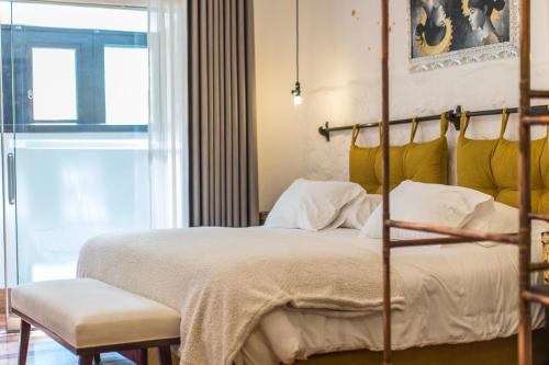 a bedroom with a large bed with a yellow headboard at X.O Art House in Cusco