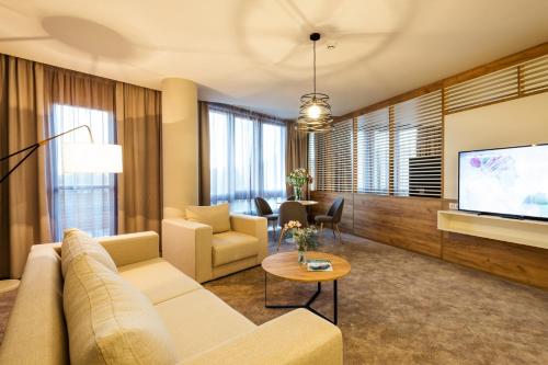 a living room with a couch and a tv at Hotel Orlovetz in Pamporovo